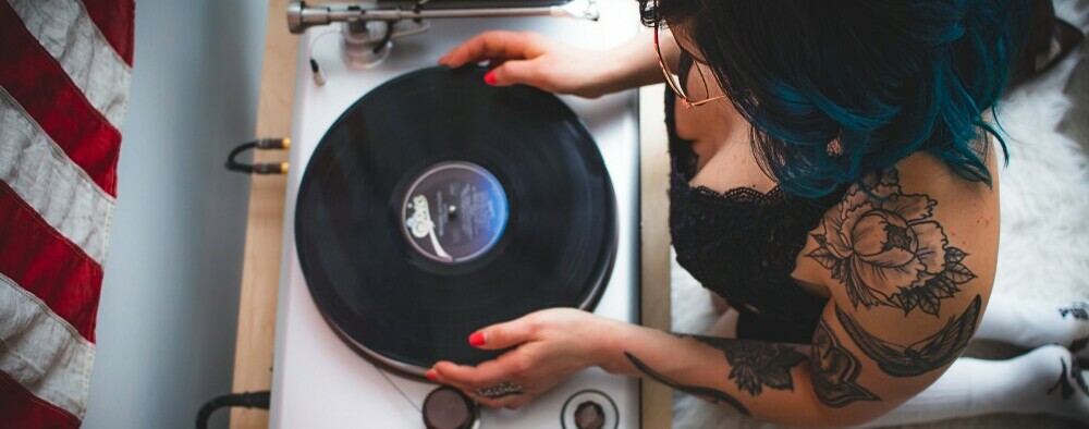 woman holding an LP, about to put it on the turntable mat